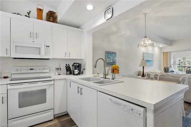 a kitchen with cabinets appliances a sink and a counter top space