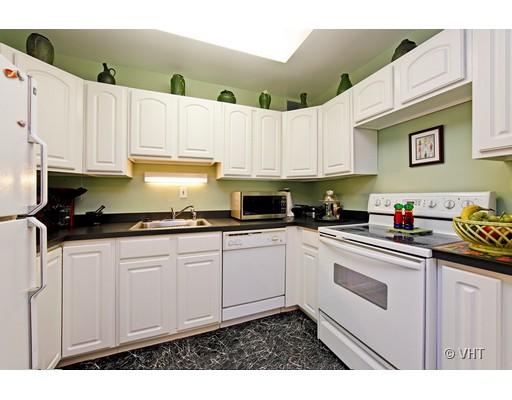 910 North Lake Shore Drive, Unit 718 Chicago, IL 60611 - Photo 6 of 10 a kitchen with granite countertop white cabinets and white appliances