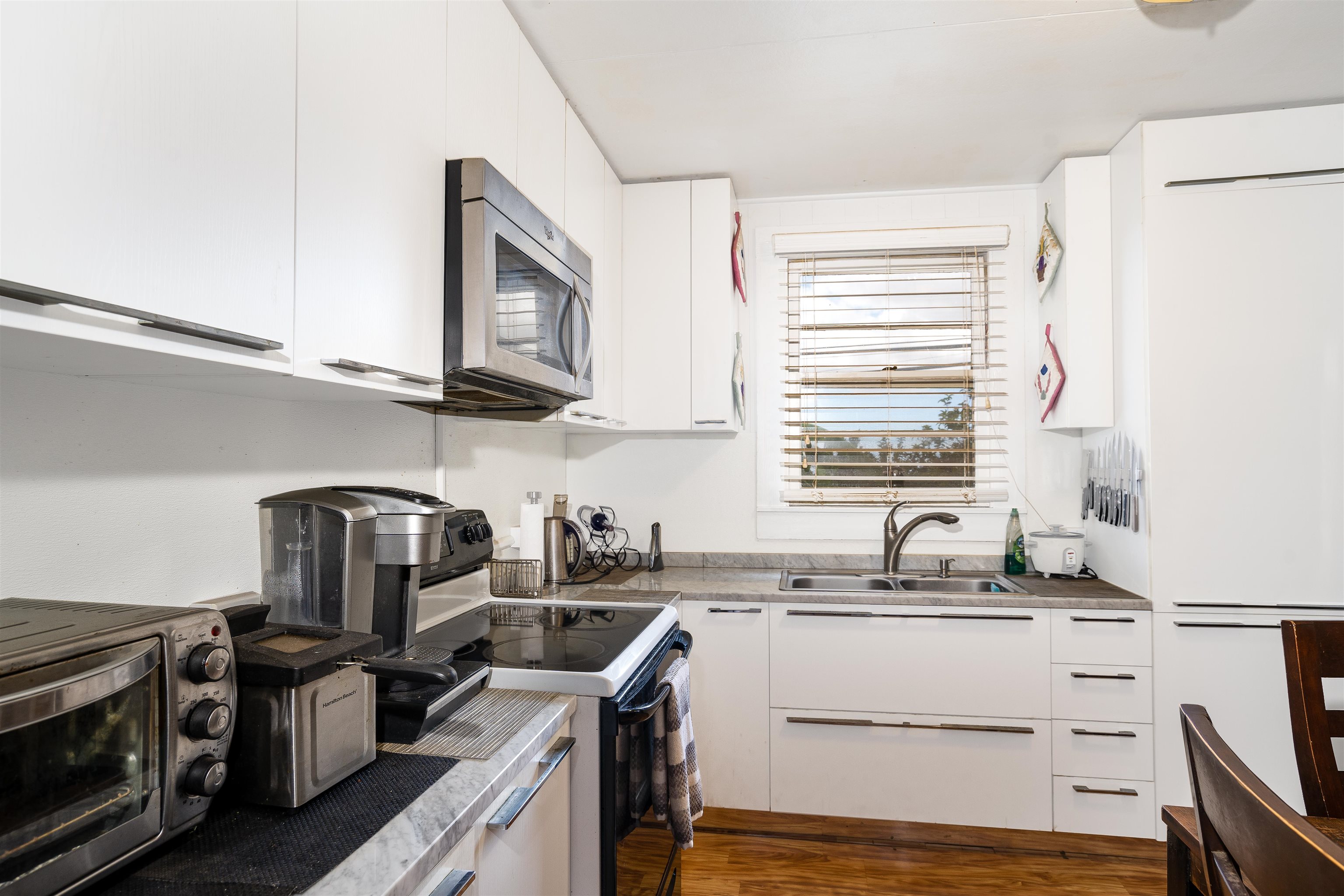 5340 Lower Kula Road Kula, HI 96790 - Photo 5 of 29 a kitchen with stainless steel appliances granite countertop a sink stove oven a sink dishwasher and cabinets with wooden floor