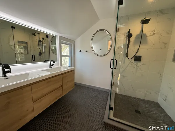 a bathroom with a granite countertop sink mirror vanity and toilet