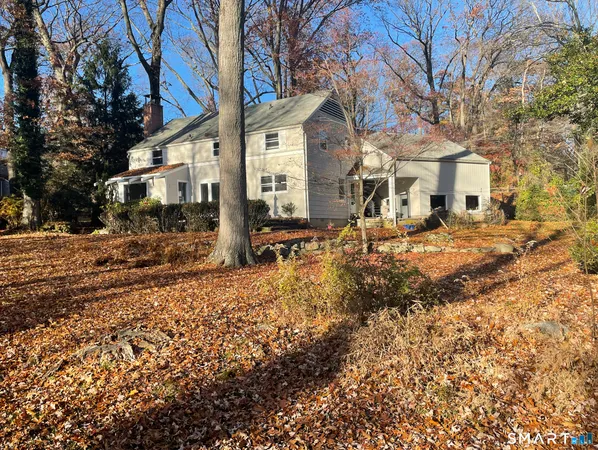 a view of a large white house with a yard covered with snow