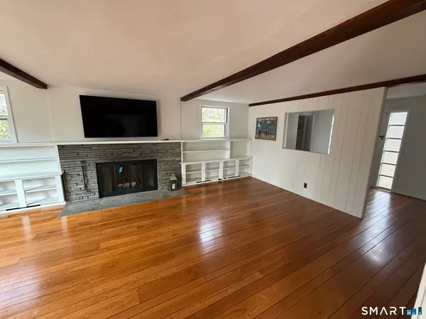 a view of a livingroom with wooden floor and a fireplace