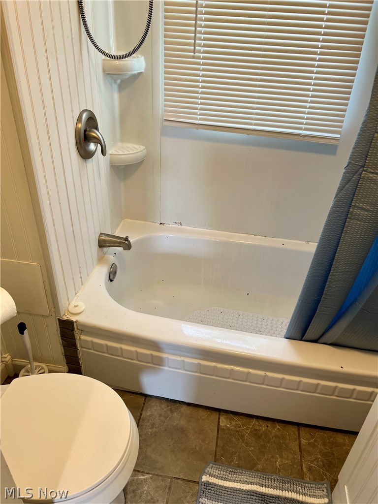1041 Two Ridge Road Wintersville, OH 43953 - Photo 14 of 19 Bathroom featuring shower / bath combo with shower curtain, toilet, and tile patterned floors