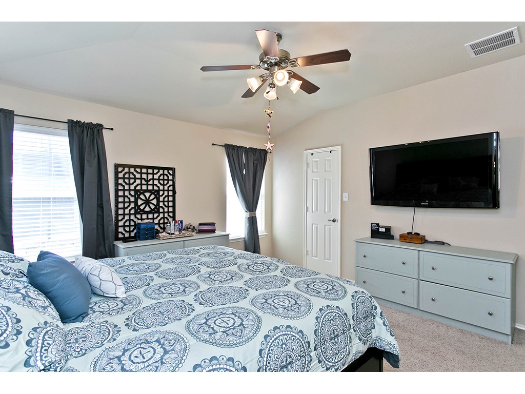 1808 Sand Creek Road Cedar Park, TX 78613 - Photo 19 of 25 Vaulted ceiling room featuring a ceiling fan with integrated lighting, textured carpeting, and dual windows with blinds