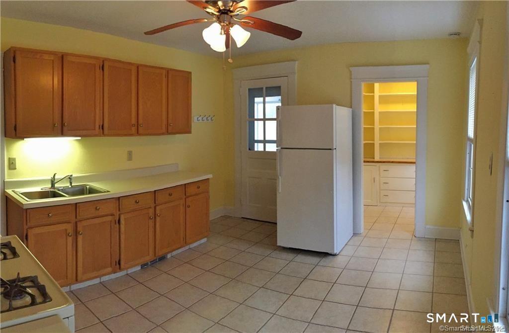 28 Grove Street Thomaston, CT 06787 - Photo 4 of 10 a kitchen with a refrigerator a sink and cabinets