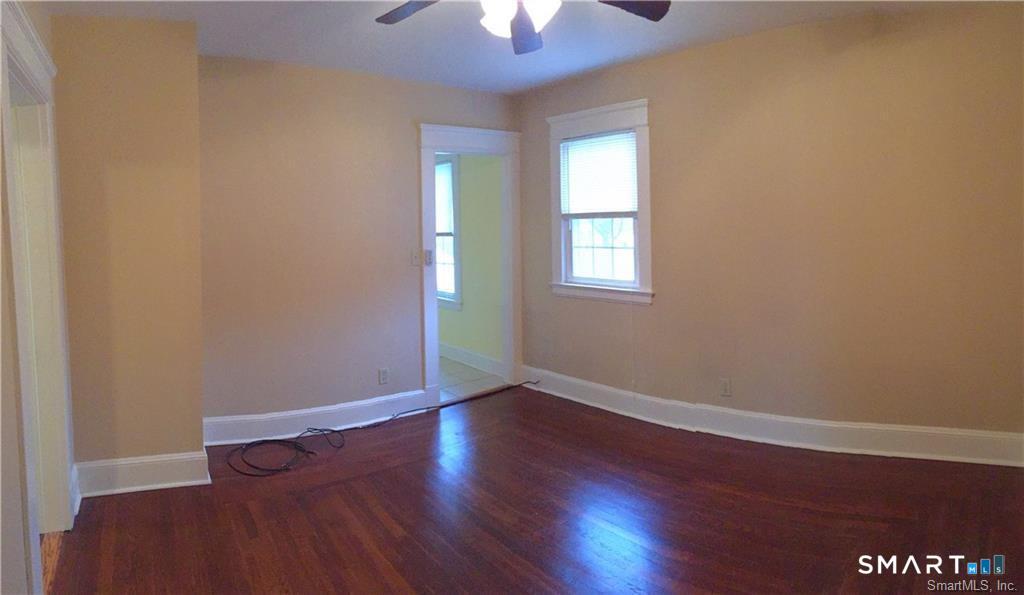 28 Grove Street Thomaston, CT 06787 - Photo 8 of 10 an empty room with wooden floor chandelier fan and windows