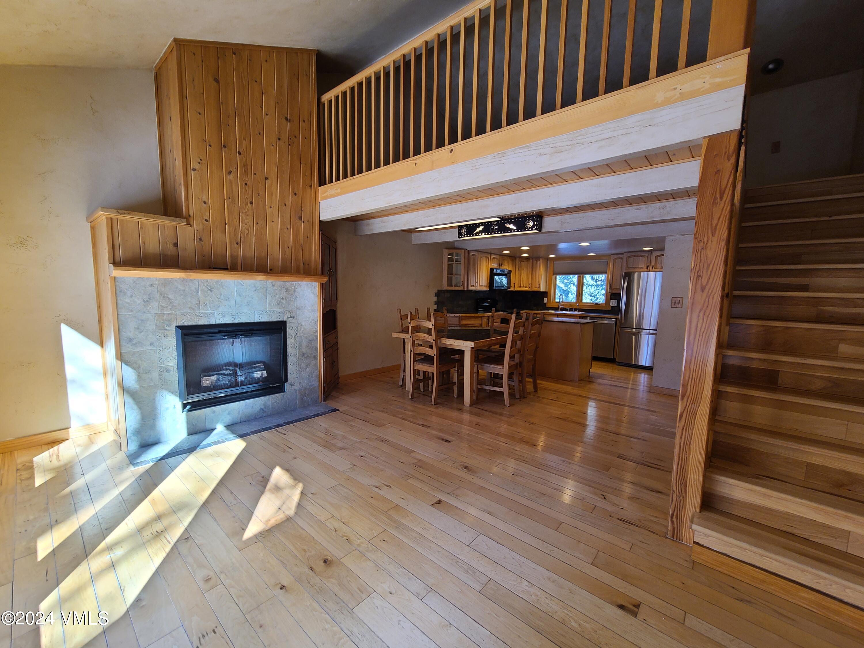 a view of a livingroom with furniture wooden floor fireplace and staircase