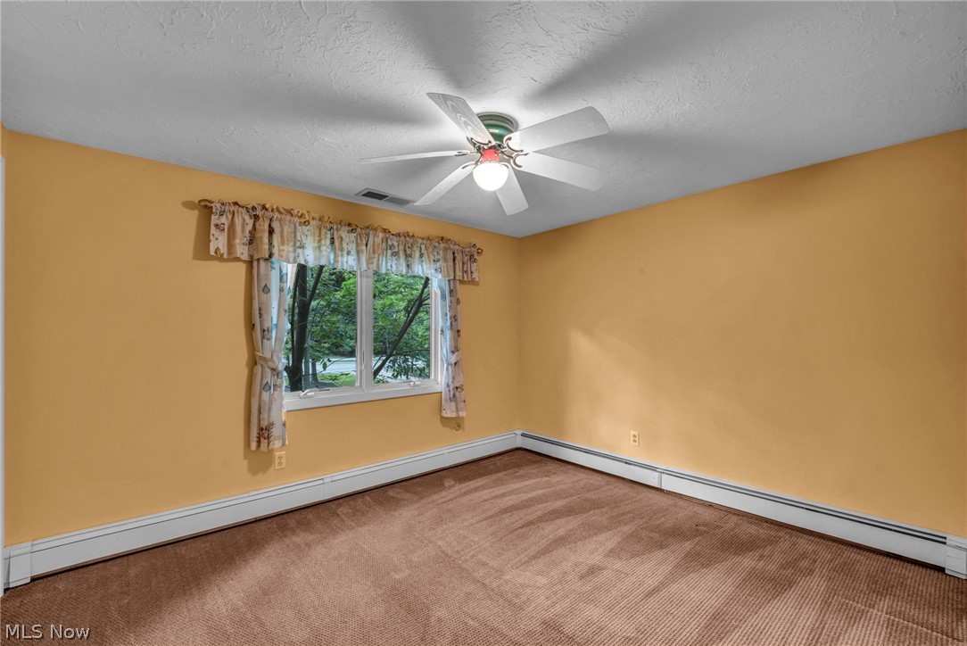 6845 Liberty Road Solon, OH 44139 - Photo 35 of 47 Room featuring a window with exterior tree views, wall-to-wall carpeting, and baseboard heating