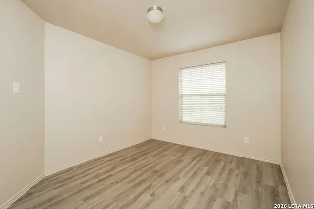 a view of a room with wooden floor and window