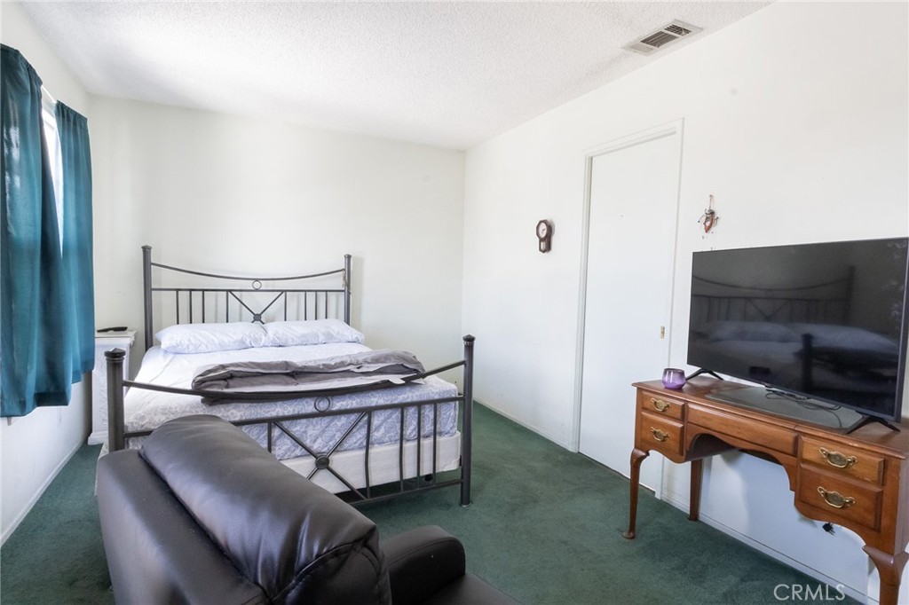 26218 McCall Boulevard Menifee, CA 92586 - Photo 14 of 33 a bedroom with a bed and a flat screen tv