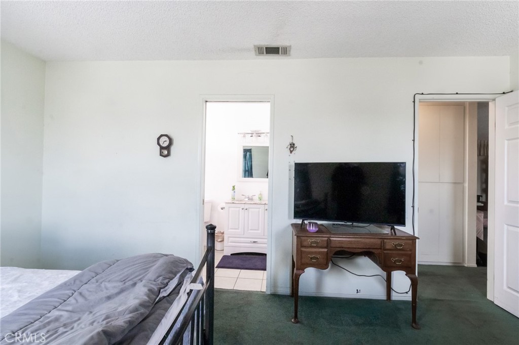 26218 McCall Boulevard Menifee, CA 92586 - Photo 15 of 33 a bedroom with a bed and a flat screen tv
