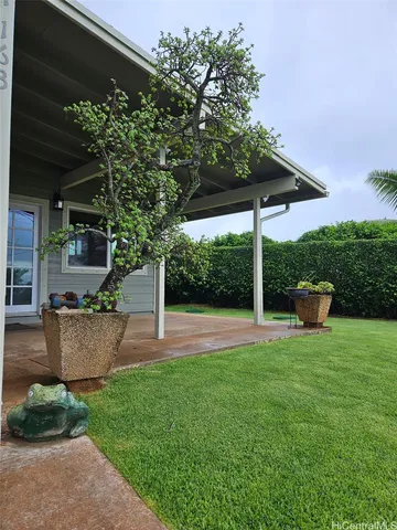 a view of a backyard with table and chairs under an umbrella