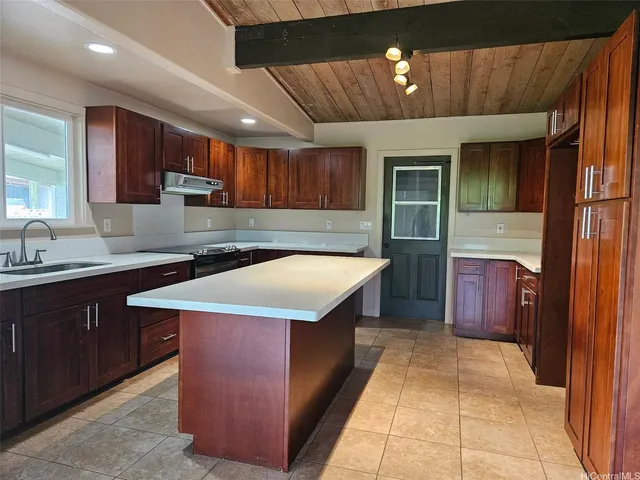 a kitchen that has a sink stainless steel appliances a counter space and a window