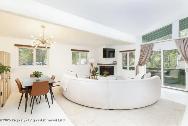 a living room with furniture a table and a large window