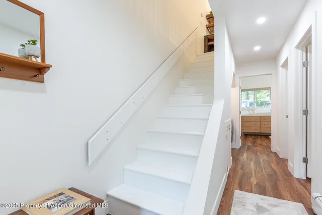 a view of entryway and hall with wooden floor
