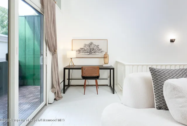 a living room with furniture and a painting on the wall