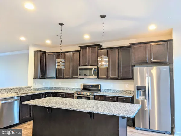a kitchen with stainless steel appliances granite countertop a sink a refrigerator and a stove