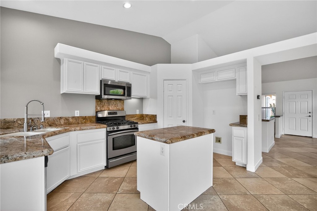 80601 Declaration Avenue Indio, CA 92201 - Photo 11 of 15 a kitchen with granite countertop a sink stove and refrigerator