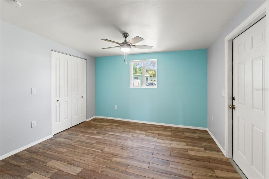 2092 Culbreath Road, Unit C52 Brooksville, FL 34602 - Photo 17 of 33 a view of empty room with wooden floor and ceiling fan
