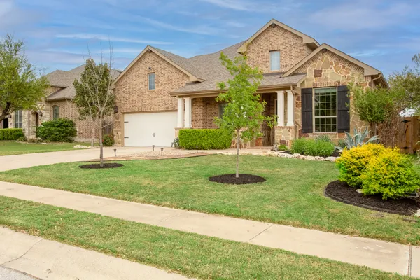 a front view of a house with a yard and garage