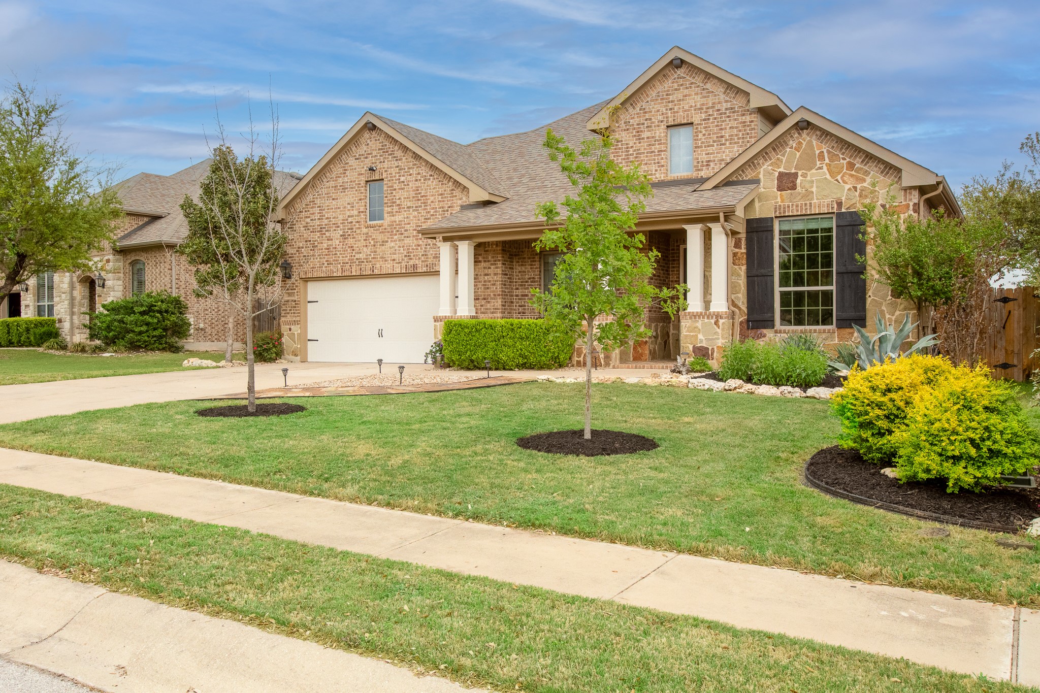 7613 Turnback Ledge Trail Lago Vista, TX 78645 - Photo 1 of 40 a front view of a house with a yard and garage