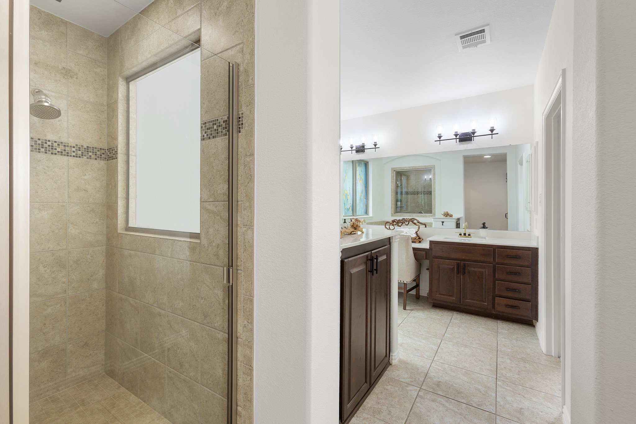 7613 Turnback Ledge Trail Lago Vista, TX 78645 - Photo 12 of 40 a bathroom with a vanity a sink a mirror a bathtub and shower