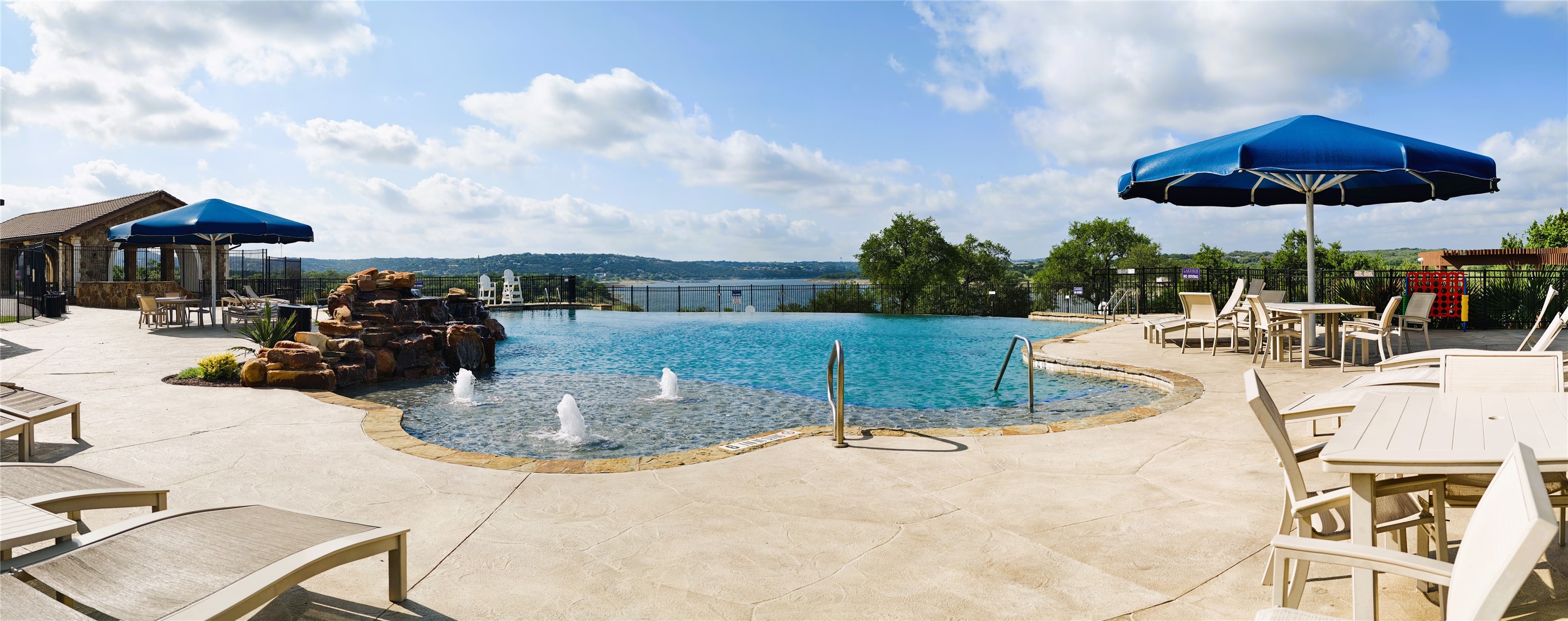 7613 Turnback Ledge Trail Lago Vista, TX 78645 - Photo 39 of 40 a view of a swimming pool with a table and chairs under an umbrella