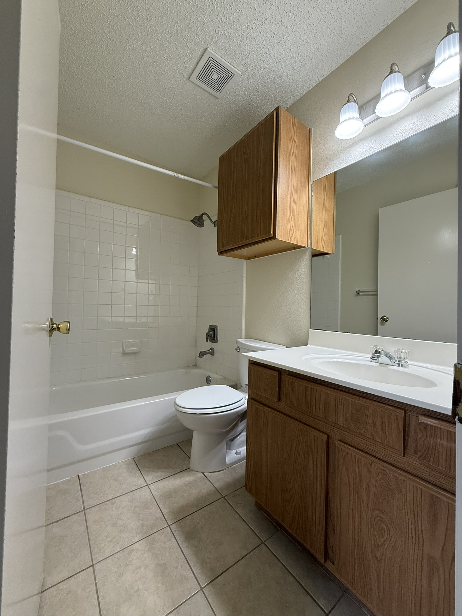 2304 Granberry Drive, Unit B Austin, TX 78745 - Photo 20 of 24 Bathroom featuring a white bathtub, ceramic tile shower surround, and a vanity with wood-finish cabinetry and an integrated sink