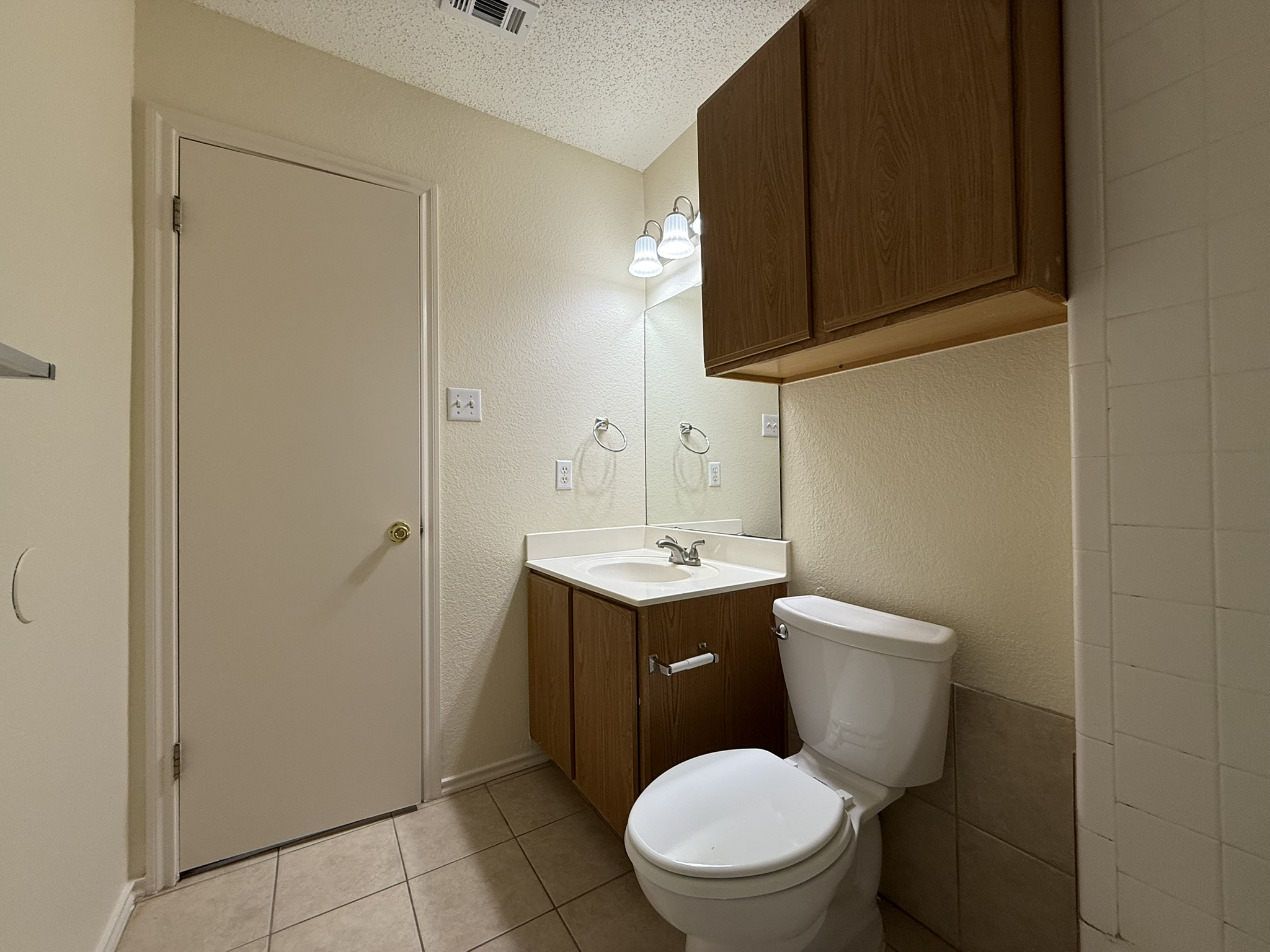 2304 Granberry Drive, Unit B Austin, TX 78745 - Photo 24 of 24 Bathroom featuring a single vanity with wood-finish cabinetry, a white countertop, and an integrated sink
