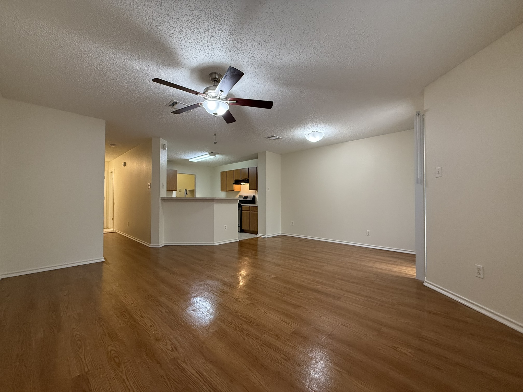 2304 Granberry Drive, Unit B Austin, TX 78745 - Photo 7 of 24 Expansive main living area featuring wood-finish flooring and a ceiling fan with integrated lighting