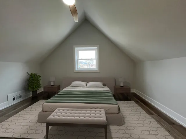 a room with a bed and a potted plant