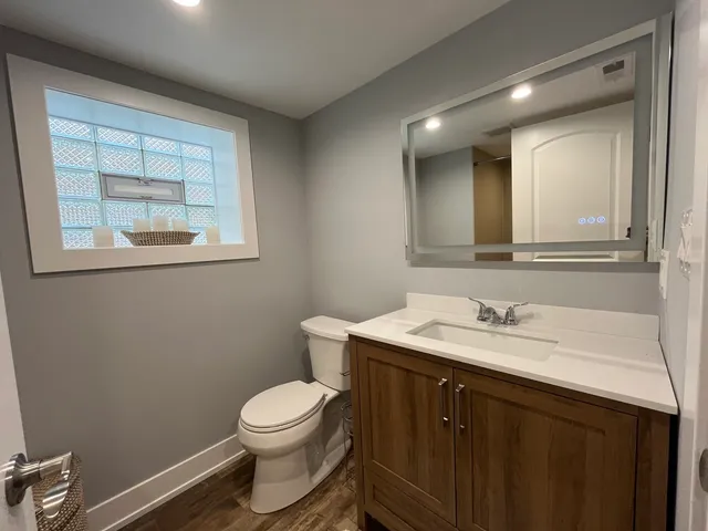 a bathroom with a toilet a sink a vanity and mirror