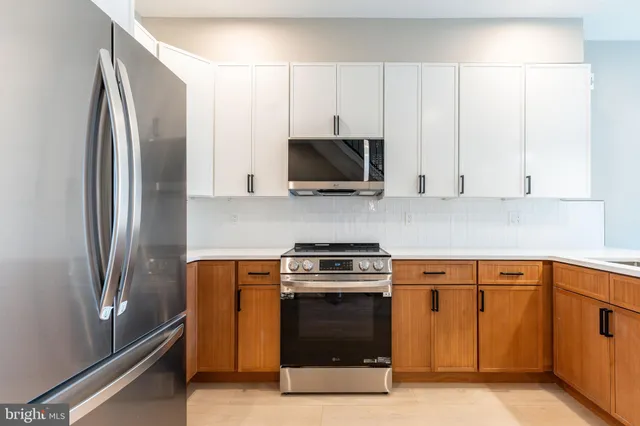 a kitchen with stainless steel appliances granite countertop a refrigerator a stove and a sink