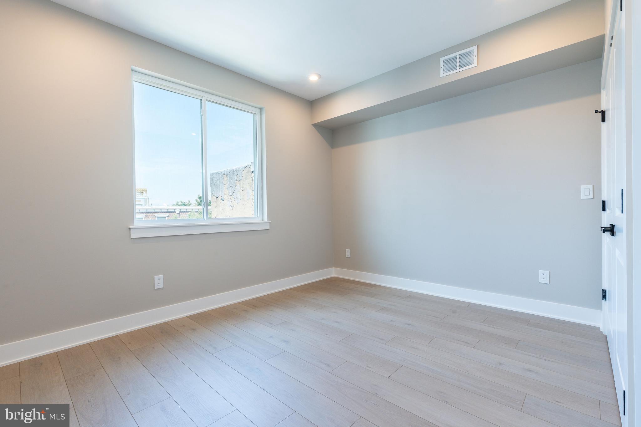 2048 North 3rd Street, Unit 2 Philadelphia, PA 19122 - Photo 16 of 27 a view of an empty room with wooden floor and a window