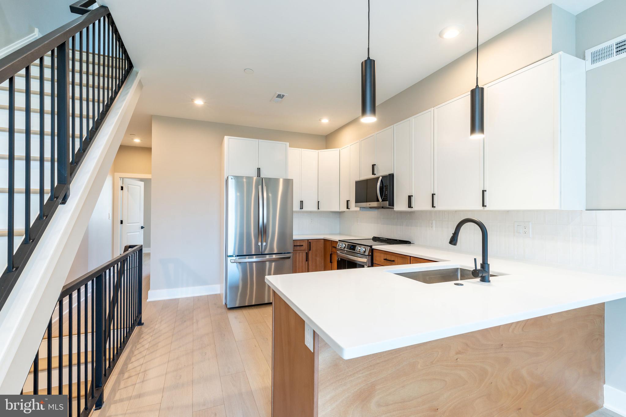 2048 North 3rd Street, Unit 2 Philadelphia, PA 19122 - Photo 5 of 27 a kitchen with stainless steel appliances granite countertop a sink refrigerator and cabinets