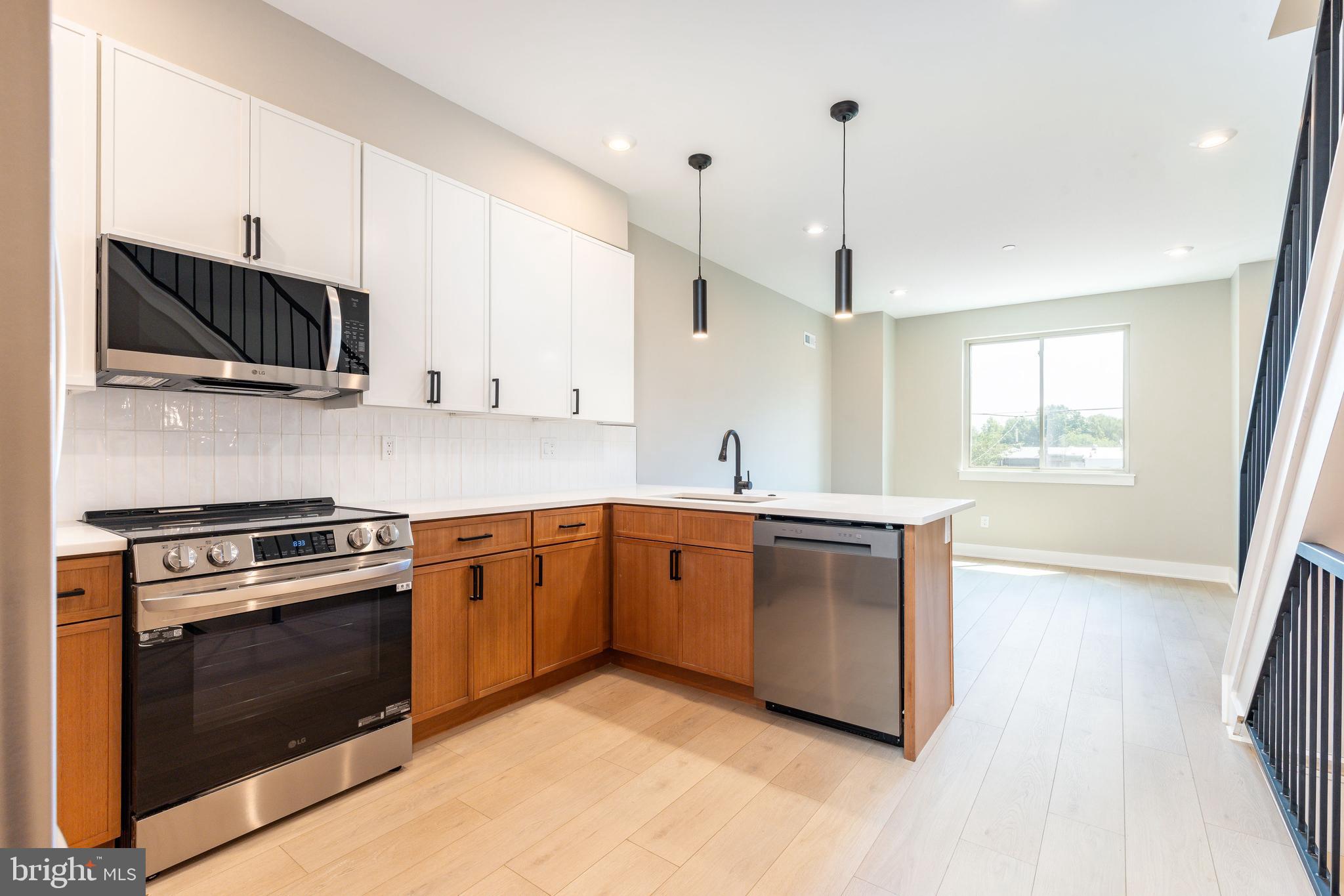2048 North 3rd Street, Unit 2 Philadelphia, PA 19122 - Photo 6 of 27 a kitchen with stainless steel appliances granite countertop a stove a sink and a microwave