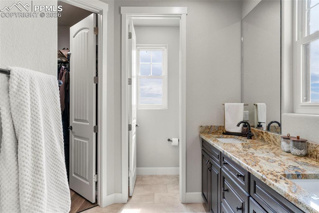 2480 North Log Road Calhan, CO 80808 - Photo 19 of 50 a bathroom with a granite countertop sink and a mirror