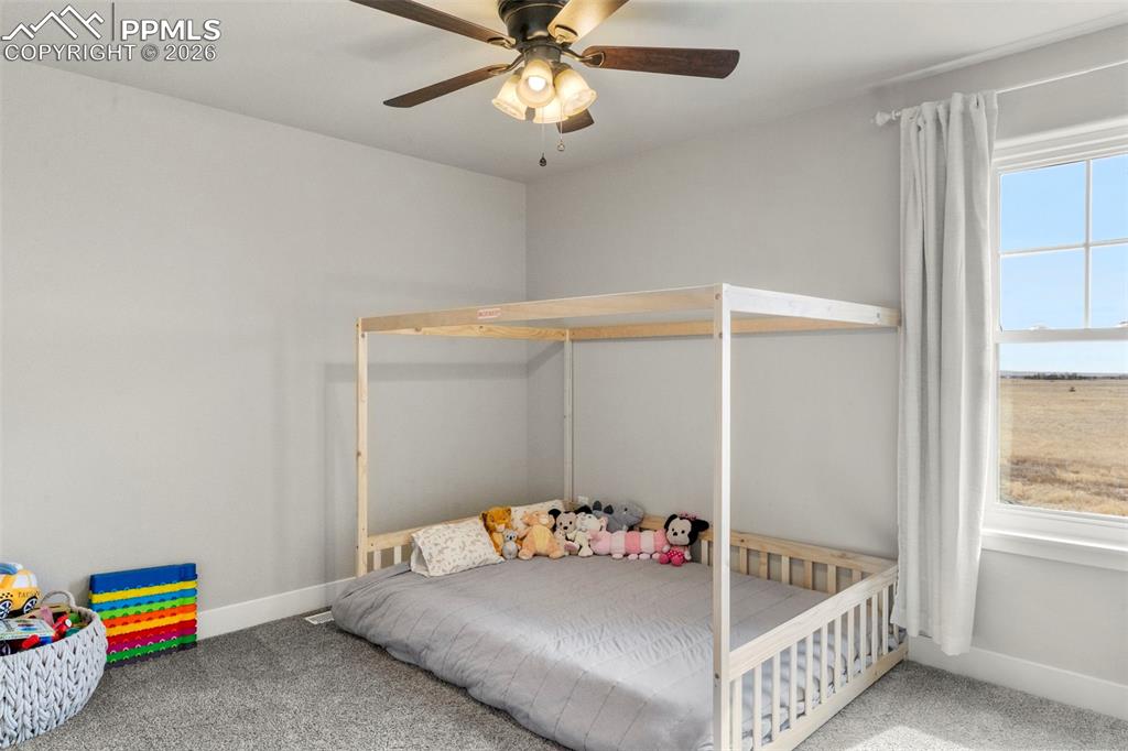 2480 North Log Road Calhan, CO 80808 - Photo 26 of 50 a bedroom with a bed and a chandelier