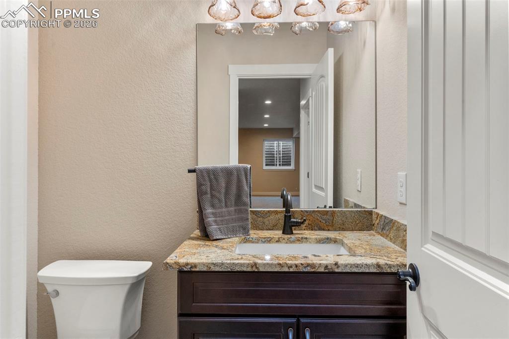 2480 North Log Road Calhan, CO 80808 - Photo 32 of 50 a bathroom with a granite countertop sink a toilet and a mirror