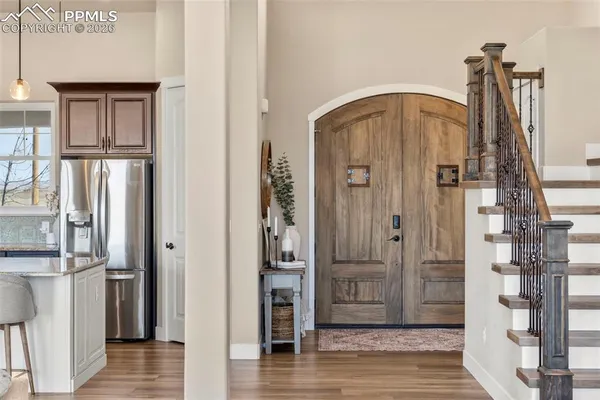 a kitchen with stainless steel appliances granite countertop a sink a stove and a wooden floors