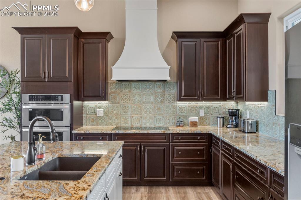 2480 North Log Road Calhan, CO 80808 - Photo 6 of 50 a kitchen with stainless steel appliances granite countertop a sink stove and cabinets