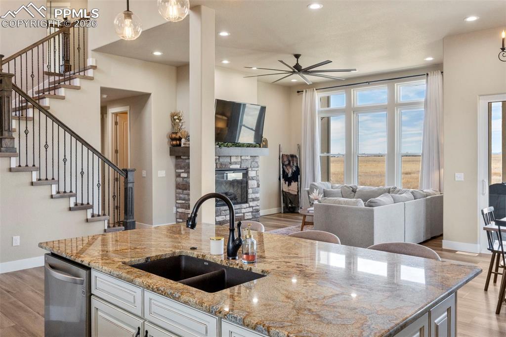 2480 North Log Road Calhan, CO 80808 - Photo 7 of 50 a kitchen with stainless steel appliances granite countertop a sink a stove and a wooden floors