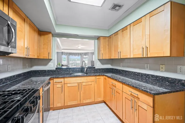 a kitchen with granite countertop a sink a counter top space and cabinets