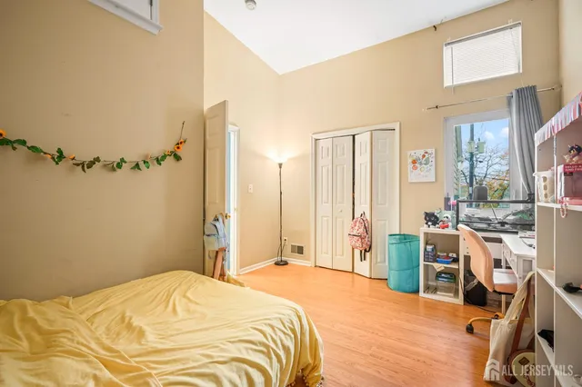 a bedroom with a bed and a flat tv screen on the dresser