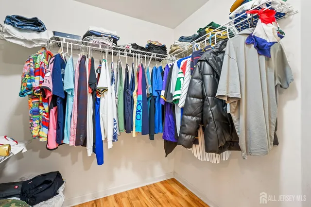 a view of walk in closet with clothes