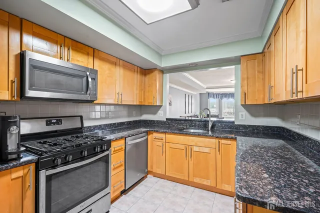 a kitchen with stainless steel appliances granite countertop a stove a sink and a microwave