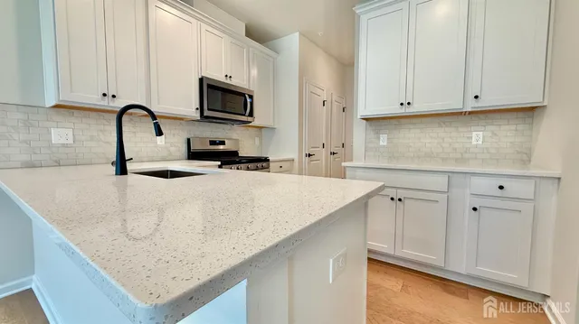 a kitchen with granite countertop white cabinets and a sink