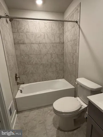 a bathroom with a toilet and a bath tub