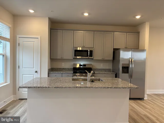 a kitchen with stainless steel appliances granite countertop a stove a sink and a refrigerator