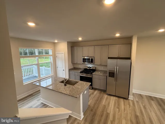 a kitchen with a refrigerator and a stove top oven